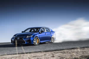 藍色Lexus轎車在沙漠道路上飄移，帶有煙霧 — Surface Pro 壁紙