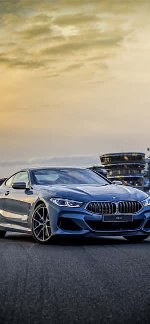 金色夕陽下賽車場上的藍色BMW跑車。