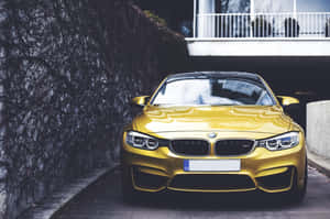 金色BMW M4轎跑車停泊在常春藤牆旁白色陽台下