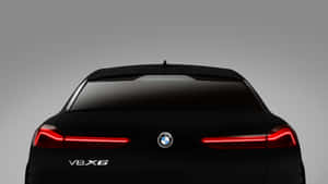 灰色背景上，黑色BMW V8X6後視圖，紅色尾燈亮起。