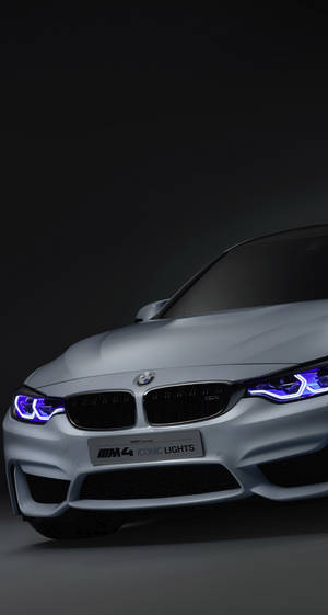 在黑暗的攝影棚環境中，銀色BMW M4配備藍色頭燈。