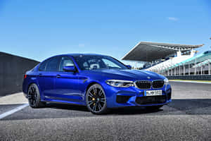 藍色BMW M5房車停放在有看台的賽道上。