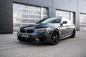 啞光黑色BMW M5性能轎車停在現代車庫外。