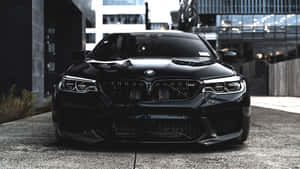 黑色BMW M5跑車停泊在混凝土上的現代都市環境。