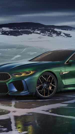 綠色BMW M8 Coupe停放在冰凍的湖面上，背景有積雪的山脈。