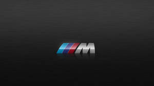 拉絲黑色金屬上的BMW M標誌，帶有彩色條紋和反射