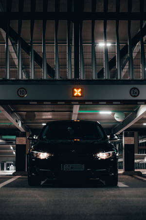 黑色汽車停放在車庫下方，上方有橙色X標誌。 — 平治 C300 壁紙