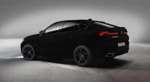 黑色BMW X6 V8X6 SUV，在工作室環境中帶有發光的紅色尾燈。