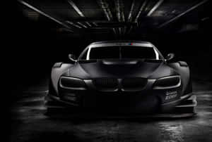在黑暗車庫中帶有Castrol EDGE品牌的啞光黑色BMW賽車。