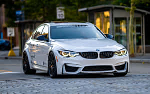 白色BMW M3拉力賽車停泊在黃昏的鵝卵石街道上。
