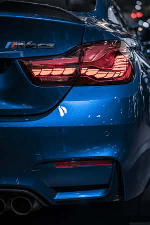 藍色BMW M4 CS跑車後視圖，帶有發光尾燈及碳纖維飾邊。
