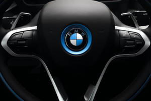 BMW i8 方向盤，帶有藍色發光標誌和控制按鈕。