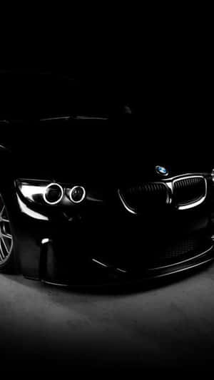 黑色BMW跑車在黑暗的攝影棚中車頭燈閃耀。