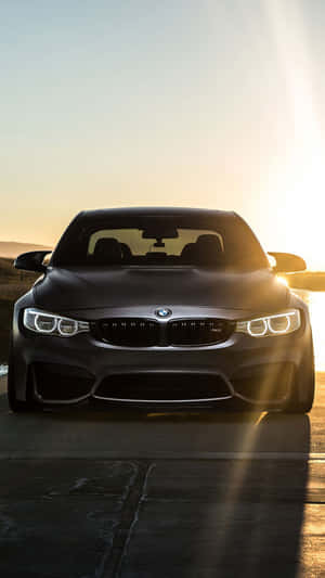 啞光黑色BMW M4在黃金時刻停放在道路上。