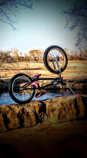 BMX單車在公園水面上方的岩石上保持平衡