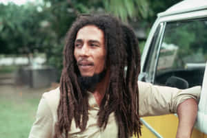 Bob Marley 靠在貨車上，背景有綠樹