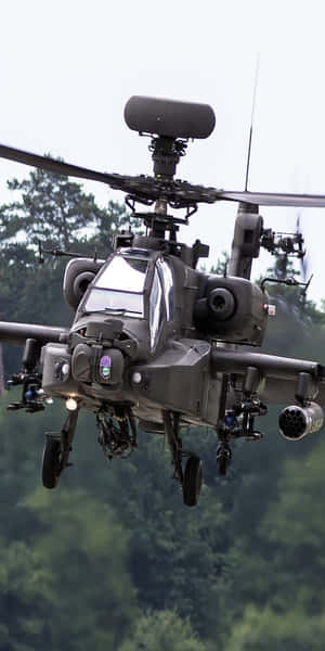 軍用攻擊直升機低空飛越森林樹冠。 — Pixel 3 壁紙