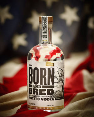 一瓶以美國國旗為背景的Born and Bred馬鈴薯伏特加酒。 — 4:5 壁紙