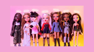 七個帶有發光光環的 Bratz 公仔排成一排，背景是粉紅色和黃色的漸變色。