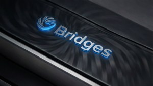 一個藍色發光的 Bridges 標誌，位於帶有金屬飾邊的深色紋理表面上。