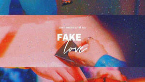 手拿著手機，在宇宙背景上顯示「FAKE love」文字。
