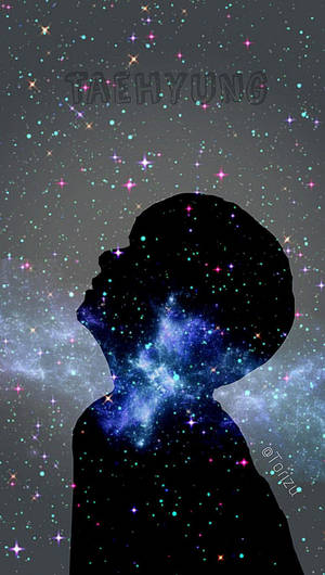 一個人的剪影，仰望有閃爍星雲的星空。
