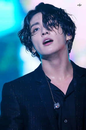 K-pop 表演者身穿黑色西裝，濕髮，舞台燈光