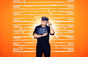 男子手持警察預約標誌，背景是心跳主題的橙色牆壁。