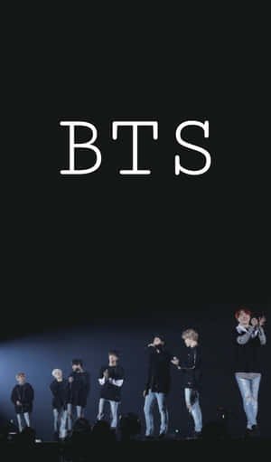 七位 BTS 成員在舞台上，聚光燈下，上方有「BTS」文字。 — Galaxy Tab A11 壁紙