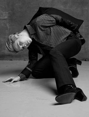 一個穿著時尚服裝的人在工作室環境中的混凝土地板上擺姿勢。 — Jimin GIF 壁紙