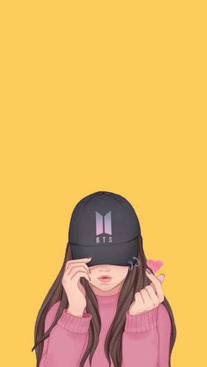 戴著BTS帽子的女孩穿著粉紅色毛衣在黃色背景前做出心形手勢