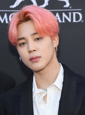 年輕男子，粉紅色頭髮和耳環，黑色西裝和白色襯衫。 — Jimin GIF 壁紙