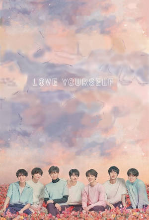 七位年輕男子坐在花朵上，粉彩天空下，帶有「LOVE YOURSELF」文字。