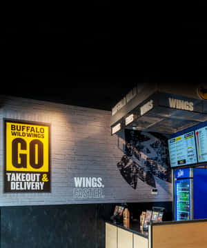 Buffalo Wild Wings餐廳內部，設有霓虹燈招牌和飲料冷卻器。