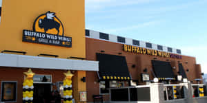 Buffalo Wild Wings 餐廳，外觀為橙色和黑色，並有黃色氣球。