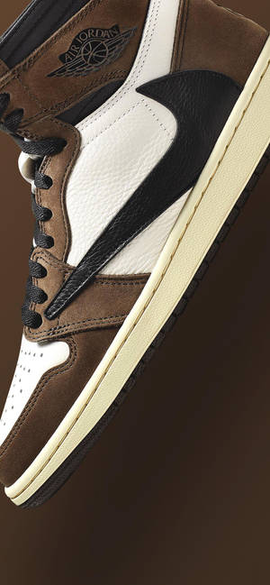 近距離拍攝一雙棕色、白色和黑色的 Air Jordan 運動鞋，配以奶油色鞋底。