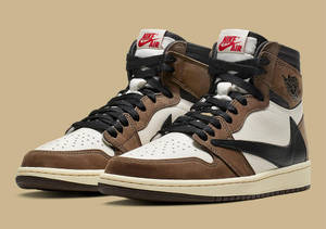 米色背景上的棕色、白色和黑色Nike Air Jordan 1高筒運動鞋。