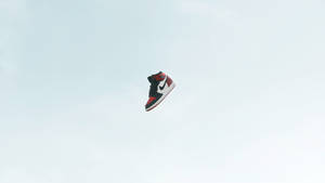 一隻運動鞋懸浮在雲層之上的天空中。 — Air Jordan GIF 壁紙