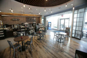 舒適的咖啡店，在溫暖吊燈下設有木地板和圓桌。