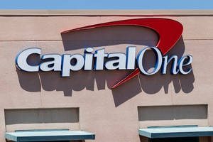 米色建築物上的 Capital One 銀行標誌，帶有紅色弧線和白色字母。
