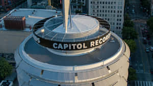 日落時從上方觀看的 Capitol Records 大樓，附近有城市交通。 — 暗色 壁紙