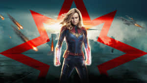 Captain Marvel 穿著戰衣，雙手發光，紅色能量光束在戰鬥場景中。 — 漫威超級英雄 壁紙