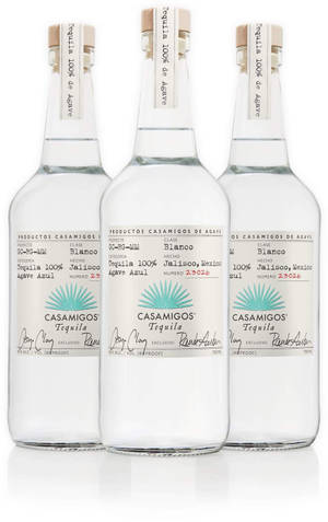 三瓶 Casamigos Tequila Blanco 整齊地擺放在白色反射表面上。