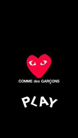 帶有眼睛的紅色心形，白色文字寫著 COMME des GARÇONS 和 PLAY，在黑色背景上。