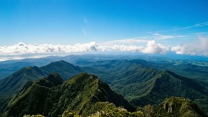 翠綠的山脊在藍天白雲下延伸。