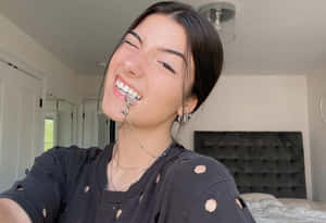 年輕女性在臥室穿著破爛黑色襯衫和銀飾大笑