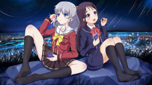 兩個穿著校服的動漫女孩坐在懸崖上，觀看夜晚閃爍的城市。