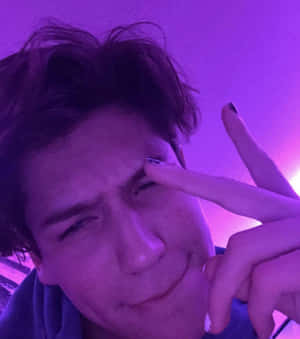 在紫色燈光下眨眼並指向眼睛的人