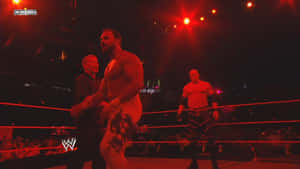 WWE摔角手在擂台上，處於紅色燈光下進行現場活動。