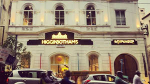 歷史悠久的白色建築，帶有 Higginbothams 標誌和繁忙的街景。